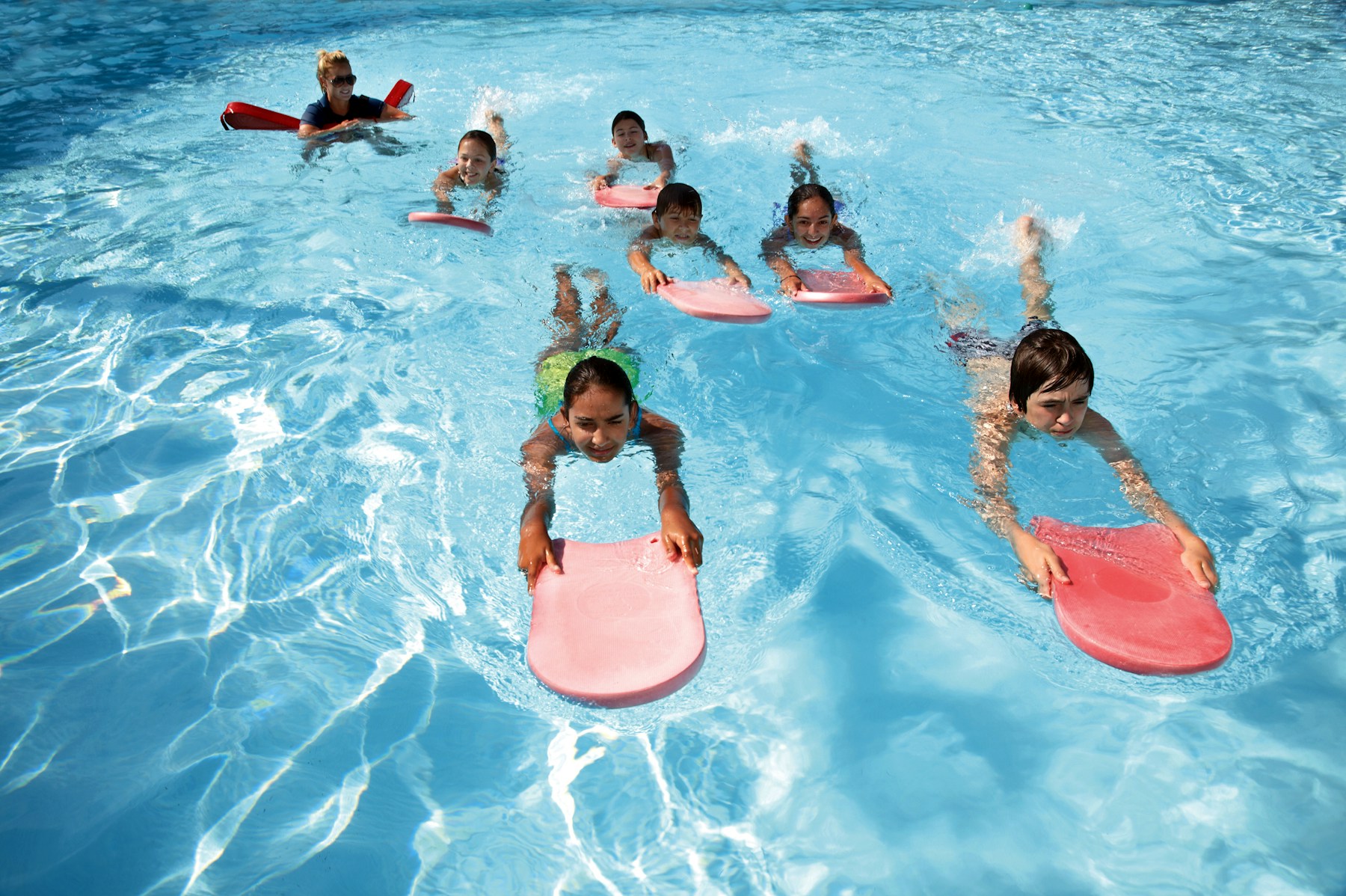 Children learning to swim with an instructor